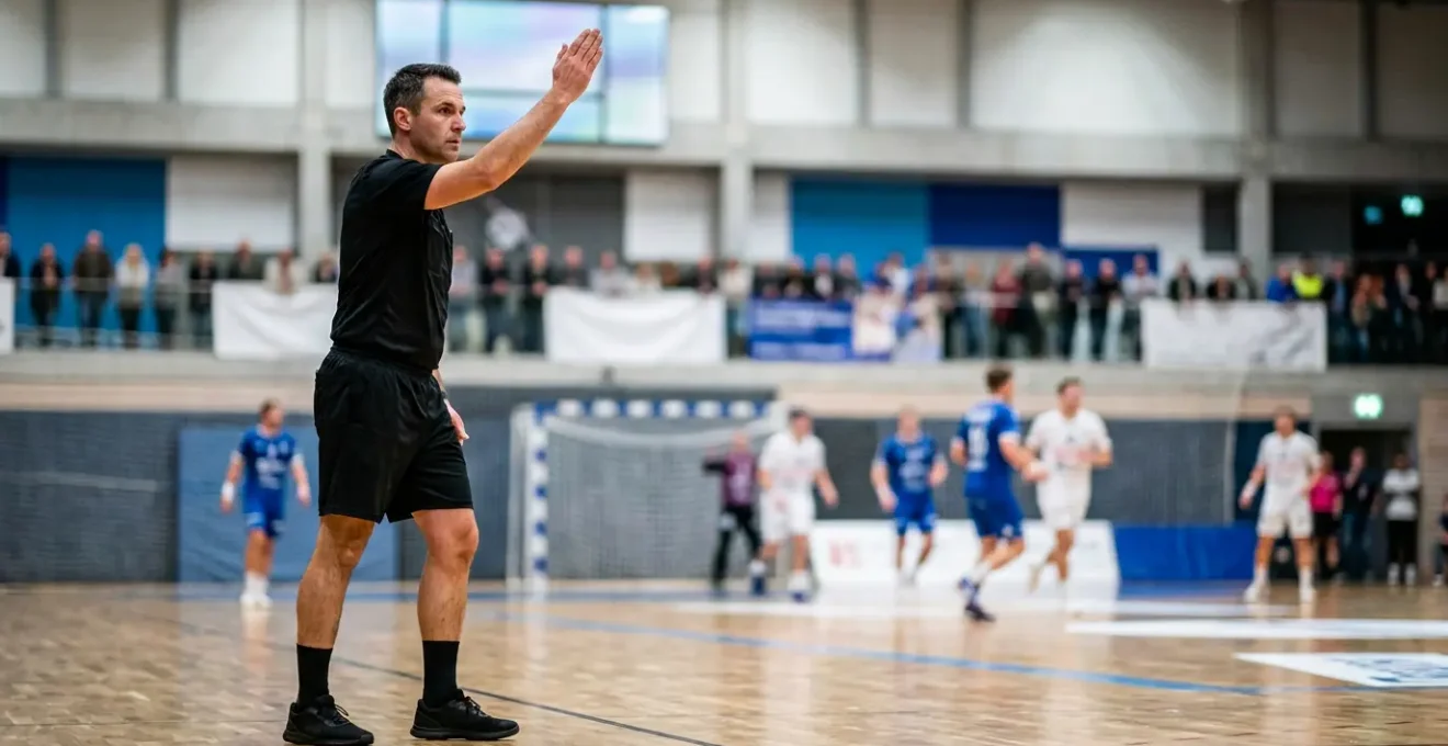 Arbitre de handball levant le bras pour signaler un avertissement de jeu passif lors d'un match en salle