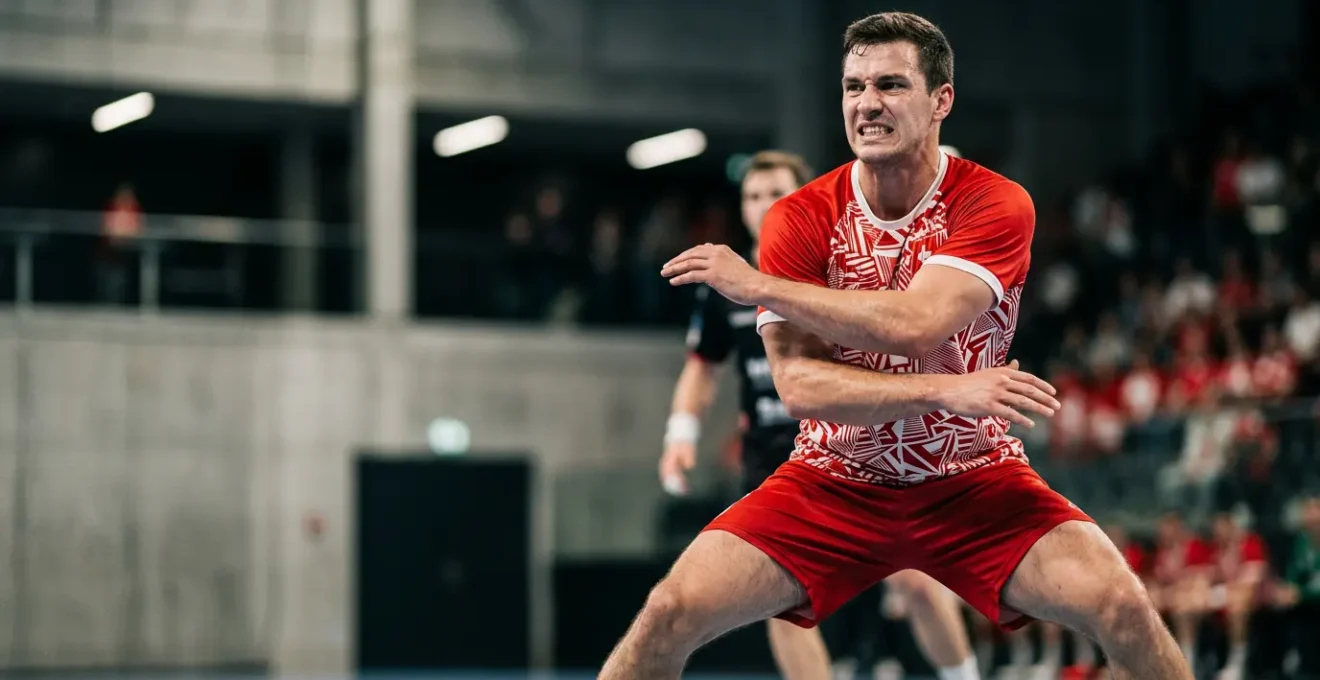 Joueur de handball en position defensive dynamique dans un match intense