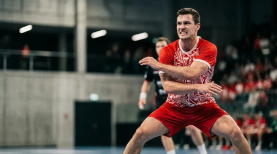 Joueur de handball en position defensive dynamique dans un match intense